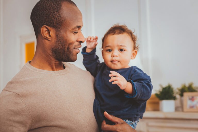 Cheerful father holding his little son