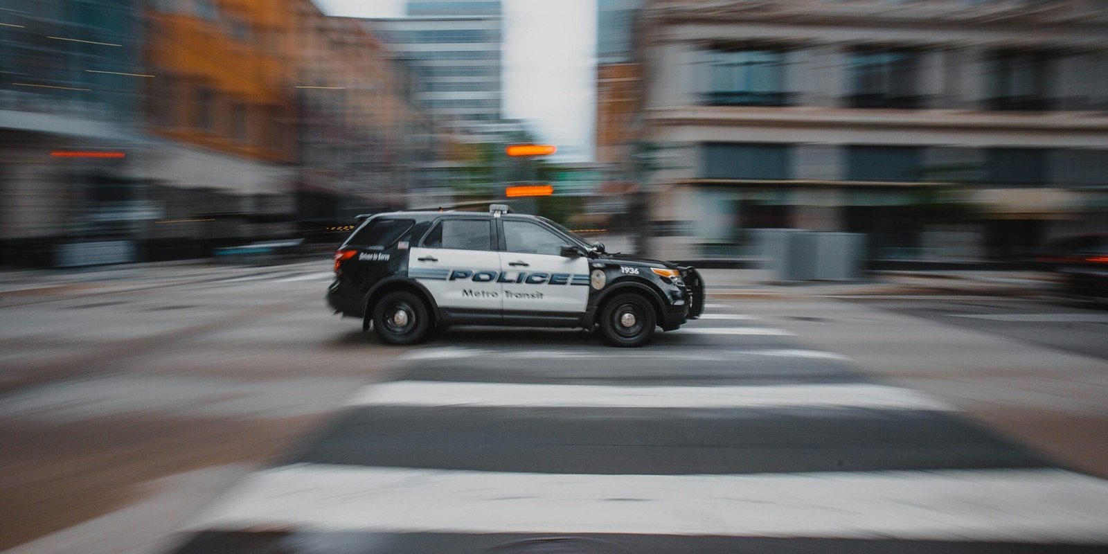 josh-hild-zXJLN5Niplw-unsplash Police car driving.